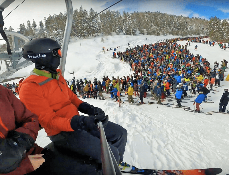 Mass tourism: long line for skiing in a mountain