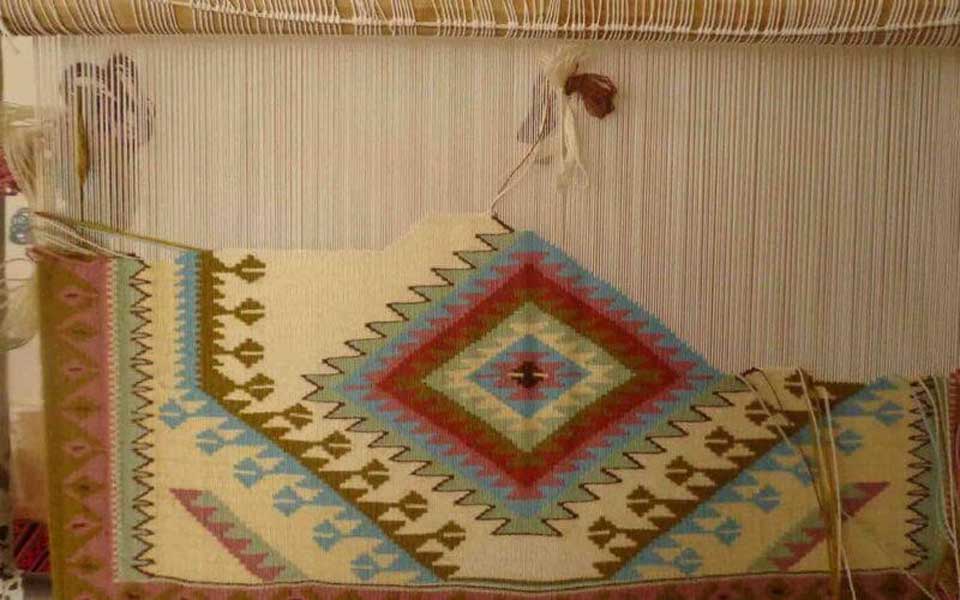 A half-finished hand-woven kilim on a Dar